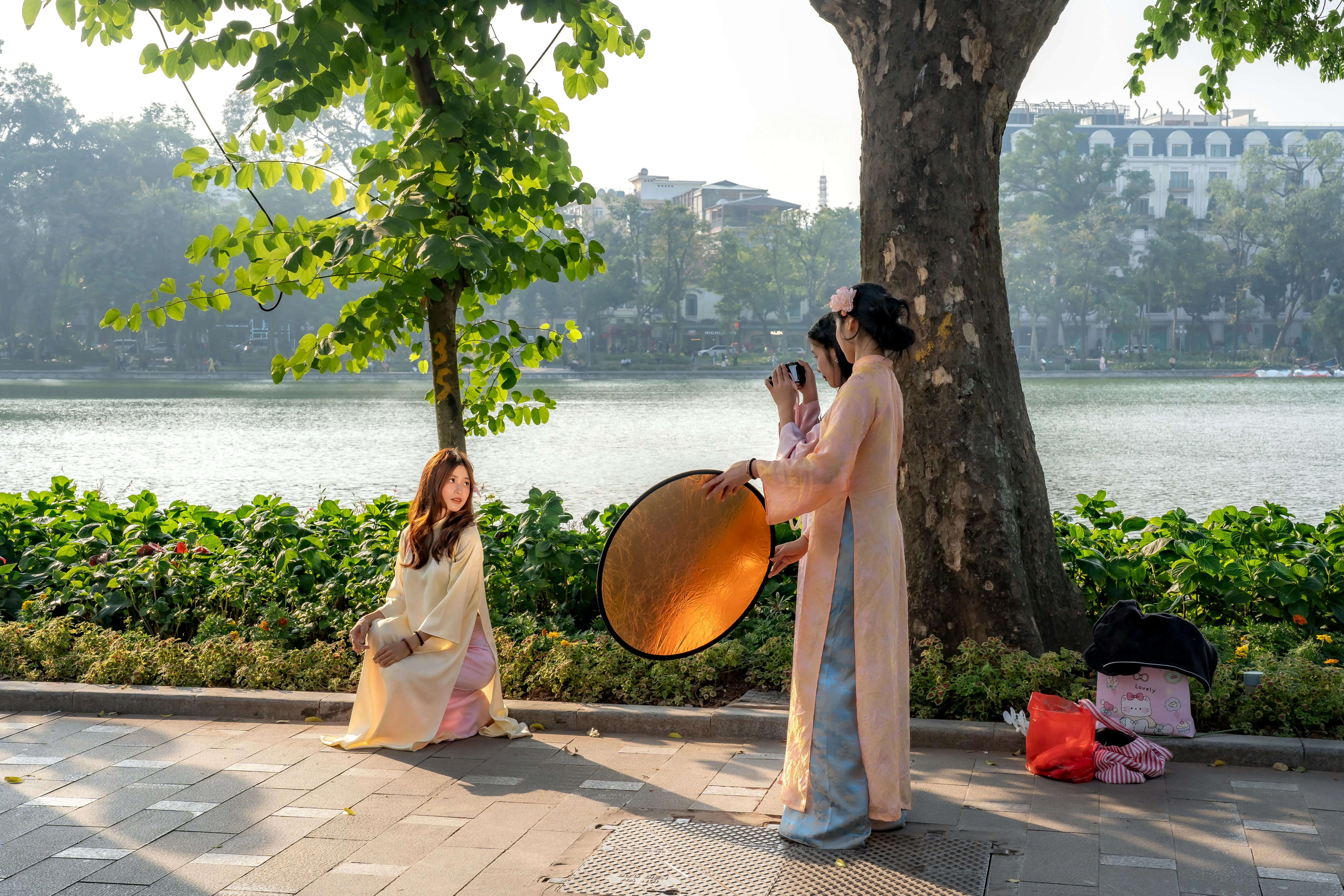 Tailor measuring customer for a wearing ao dai fitting in colorful shop in Vietnam